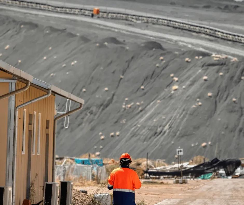 Australian professional drafting a cover letter with notes and charts nearby.